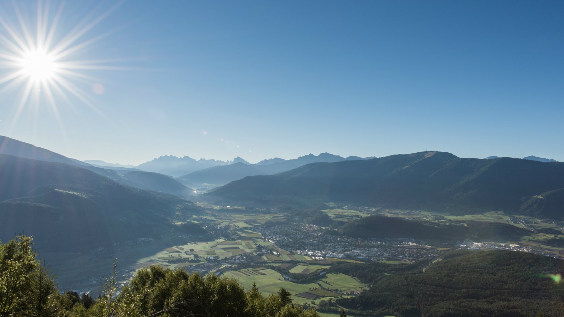 Sonniger Tag mit Blick auf Tal und Berge unter klarem Himmel